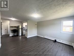 London South (South I) multi-family for rent - A room with wood flooring and a window on the right side.