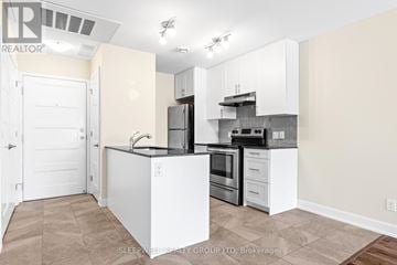 Russell multi-family for rent - A kitchen with white cabinets and a black countertop.