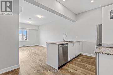 Russell multi-family for rent - A kitchen with white cabinets and a wooden floor.