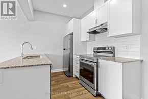 Russell multi-family for rent - A modern kitchen with white cabinets and stainless steel appliances.