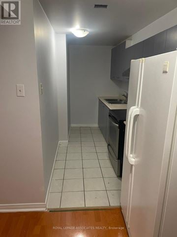 Markham (Cedarwood) apartment for rent - A white refrigerator is in a kitchen with white tile flooring.