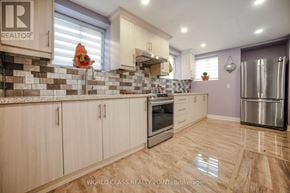 Oakville (Go Glenorchy) apartment for rent - A kitchen with wooden cabinets and a tile backsplash.