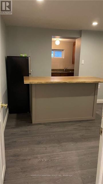 Toronto (Downsview-Roding-Cfb) apartment for rent - A kitchen with a black refrigerator and a wooden counter.