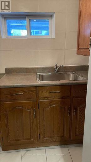 Toronto (Downsview-Roding-Cfb) apartment for rent - A kitchen with wooden cabinets and a stainless steel sink.