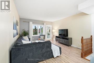 North Grenville townhouse for rent - A living room with a grey couch and a television.