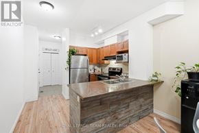 North Grenville townhouse for rent - A kitchen with a refrigerator, sink, and microwave.
