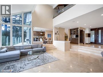 West Vancouver apartment for rent - A spacious living room with a grey sofa and a glass coffee table.