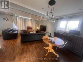 Toronto (Dorset Park) apartment for rent - A living room with a black couch, a wooden table, and a television.