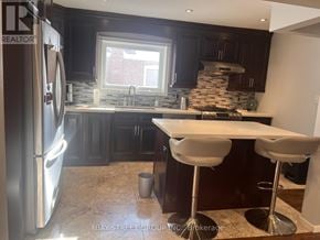 Toronto (Dorset Park) apartment for rent - A modern kitchen with dark wood cabinets and a stainless steel refrigerator.