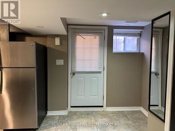 Mississauga (Hurontario) apartment for rent - A kitchen with a refrigerator, a door, and a window with blinds.