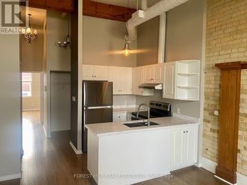 Cambridge townhouse for rent - A kitchen with white cabinets and a brick wall.
