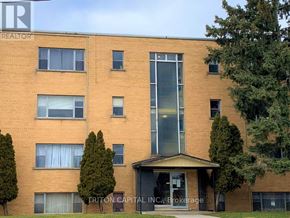 Hamilton (Dundas) apartment for rent - A brick building with a sign that says Triton Capital.