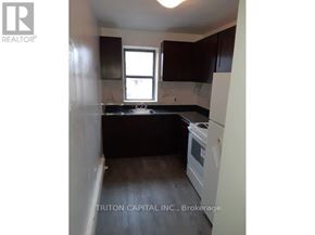 Hamilton (Dundas) apartment for rent - A kitchen with a white oven and dark cabinets.