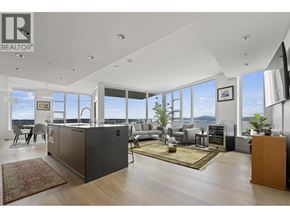 Vancouver apartment for rent - A modern living room with a large kitchen island and a view of the ocean.