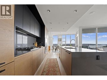 Vancouver apartment for rent - A modern kitchen with wooden cabinets and a large window overlooking the water.