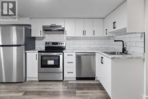 Windsor multi-family for rent - A modern kitchen with white cabinets and stainless steel appliances.