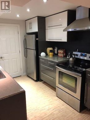 Aurora (Aurora Village) apartment for rent - A modern kitchen with a stainless steel refrigerator, oven, and wooden flooring.