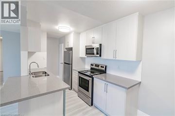 Niagara Falls apartment for rent - A modern kitchen with white cabinets and stainless steel appliances.