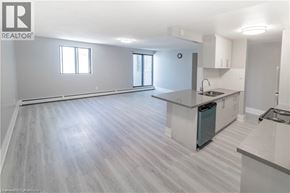 Niagara Falls apartment for rent - A spacious kitchen and living room with light grey flooring and white walls.