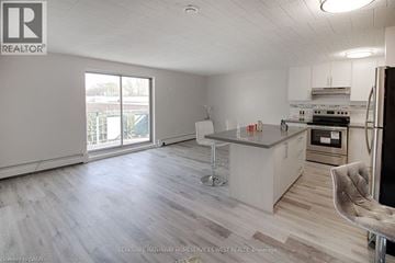 Niagara Falls condo for rent - A spacious kitchen with a bar stool and a refrigerator.