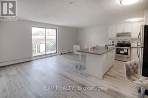 Niagara Falls (Stamford) multi-family for rent - A kitchen with a bar stool and a chair in front of it.