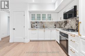 Toronto (Englemount-Lawrence) condo for rent - A kitchen with white cabinets and a marble backsplash.