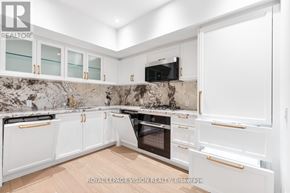 Toronto (Englemount-Lawrence) condo for rent - A kitchen with white cabinets and a marble backsplash.