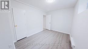 Toronto (South Parkdale) multi-family for rent - A small white refrigerator in a narrow hallway.