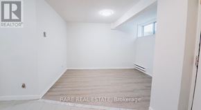 Toronto (South Parkdale) multi-family for rent - A white room with a wooden floor and a window.
