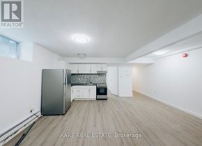 Toronto (South Parkdale) multi-family for rent - A room with wooden flooring and white walls, with a window on the right side.