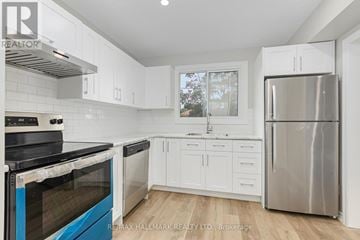 Whitby (Downtown Whitby) apartment for rent - A kitchen with white cabinets and a blue stove top oven.