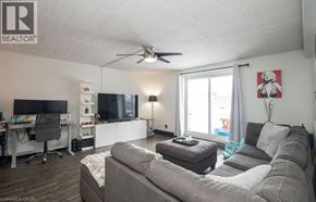 Kitchener condo for rent - A living room with a grey couch and a television.