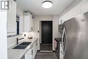 Kitchener condo for rent - A living room with a grey couch and a television.