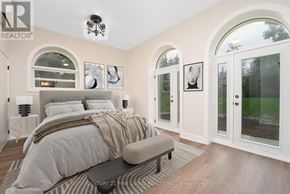 Oro-Medonte (Hawkestone) multi-family for rent - A bedroom with a large bed and a chandelier.