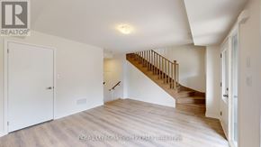 Oshawa (Eastdale) townhouse for rent - A spacious room with a staircase leading to the upper level.