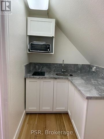 Toronto (Forest Hill South) fourplex for rent - A kitchen with white cabinets and a marble countertop.