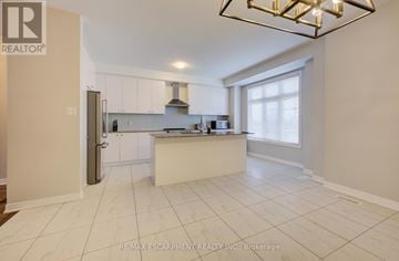 Oakville (Wm Westmount) townhouse for rent - A kitchen with white cabinets and a large island.