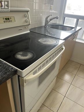 Toronto (Dovercourt-Wallace Emerson-Junction) apartment for rent - A white oven with a black stove top is in a kitchen.