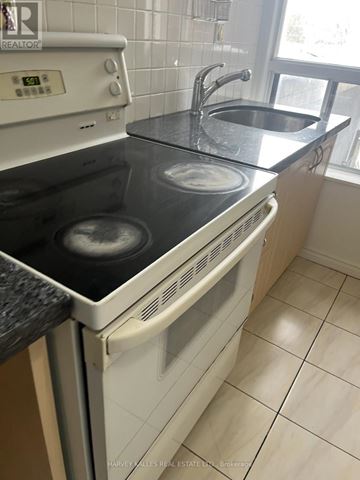 Toronto (Dovercourt-Wallace Emerson-Junction) apartment for rent - A white oven with a black stove top is in a kitchen.
