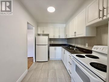 Toronto (Bendale) condo for rent - A kitchen with white cabinets and a white fridge.