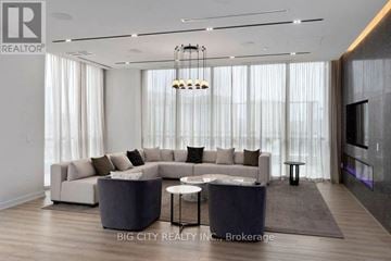 Toronto (Henry Farm) condo for rent - A modern living room with a large sectional sofa and a coffee table.