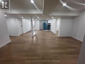 Clarington (Bowmanville) apartment for rent - A spacious room with wooden flooring and white walls, with a blue cabinet in the corner.