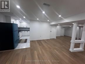 Clarington (Bowmanville) apartment for rent - A spacious room with wooden flooring and white walls.