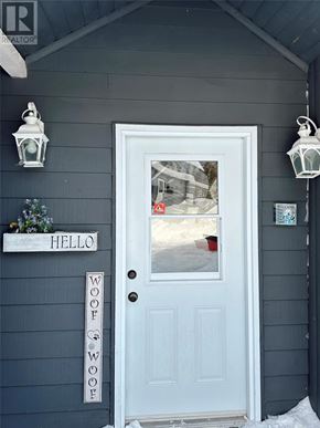 For rent in Bonne Bay - A white door with a sign that says "WOOF" on it.