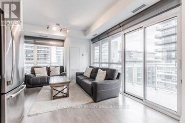 Toronto (Mimico) condo for rent - A modern living room with a grey couch and a large window.