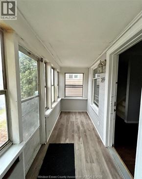 Windsor apartment for rent - A hallway with a black mat on the floor and windows on both sides.