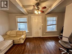 Windsor apartment for rent - A living room with a beige couch and a ceiling fan.