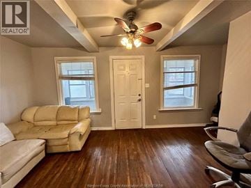 Windsor apartment for rent - A living room with a beige couch and a ceiling fan.