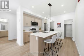 Ottawa multi-family for rent - A modern kitchen with a large island and a washing machine tucked away in the corner.