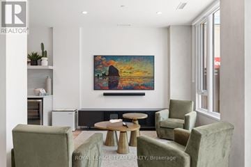 Ottawa apartment for rent - A living room with a large painting on the wall and a coffee table in the center.